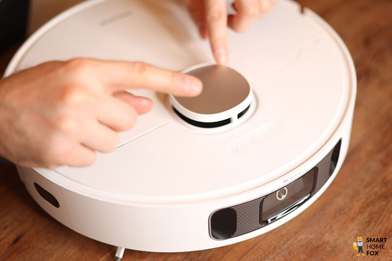 Der Lasernavigationsturm des Dreame L10s Ultra wird mit beiden Händen berührt.